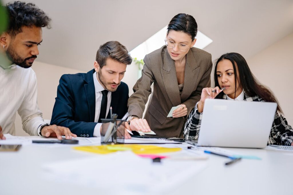 Business team working together at desk with documents and laptop in a contemporary office.